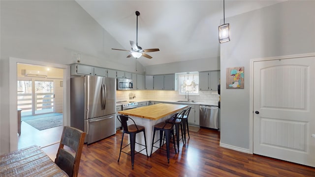 kitchen featuring backsplash, a center island, a breakfast bar, sink, and appliances with stainless steel finishes