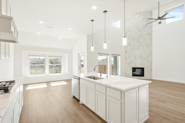 kitchen with open floor plan, plenty of natural light, dishwasher, and a sink