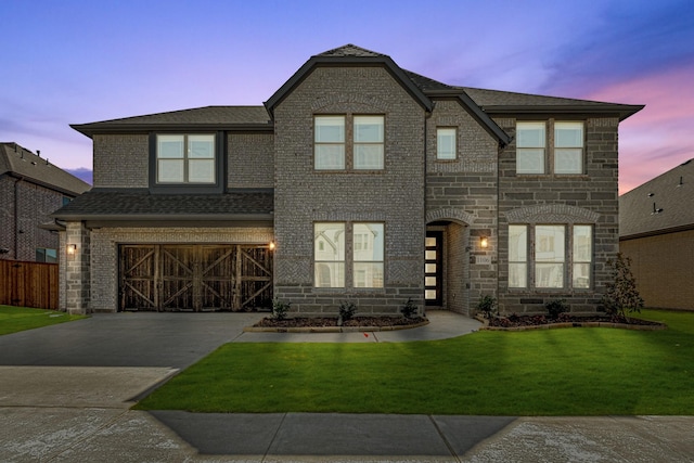 view of front of home featuring stone siding, roof with shingles, concrete driveway, an attached garage, and a front yard