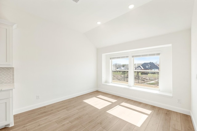 unfurnished room with recessed lighting, baseboards, lofted ceiling, and light wood finished floors