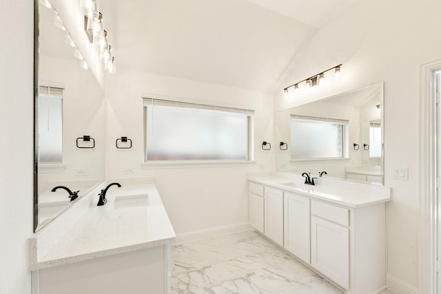 bathroom featuring baseboards, lofted ceiling, two vanities, marble finish floor, and a sink