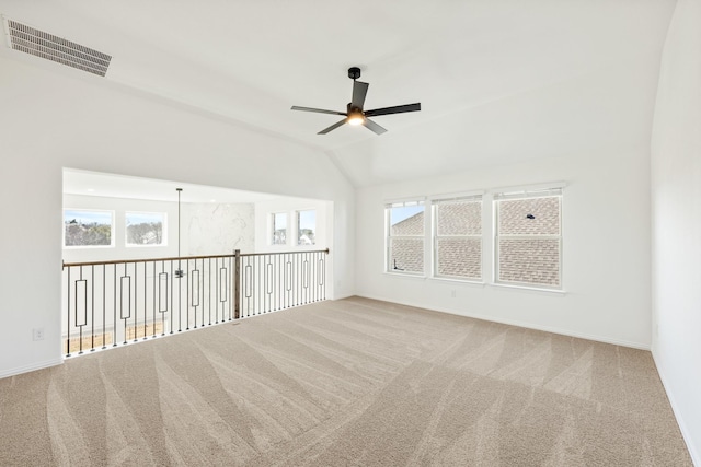 carpeted empty room featuring visible vents, baseboards, ceiling fan, and vaulted ceiling