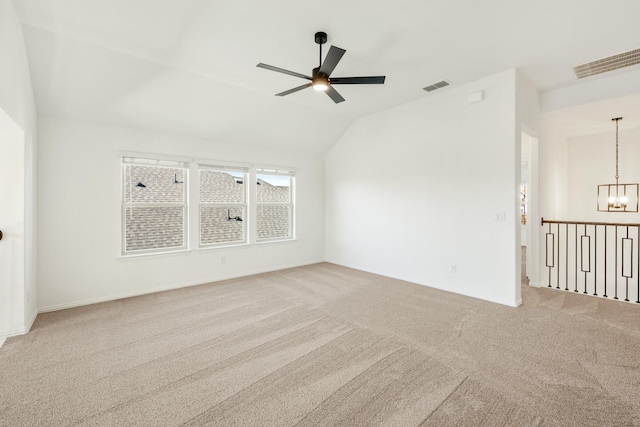 unfurnished room featuring carpet, vaulted ceiling, ceiling fan with notable chandelier, and visible vents