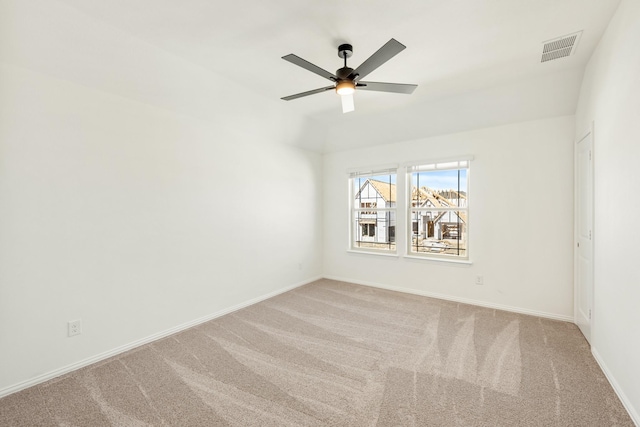 carpeted spare room with baseboards, visible vents, and ceiling fan