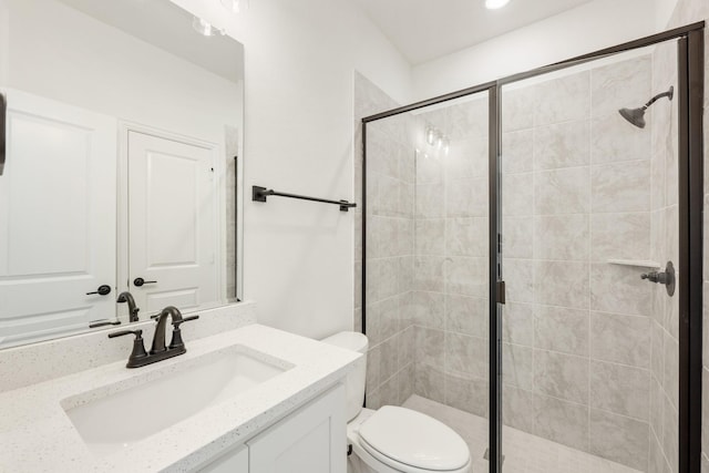 bathroom with toilet, a stall shower, and vanity