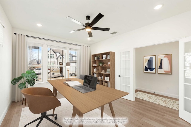 home office with light wood-type flooring, visible vents, baseboards, and a ceiling fan