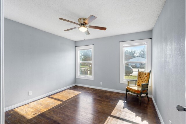 living area featuring dark hardwood / wood-style flooring, a wealth of natural light, and ceiling fan