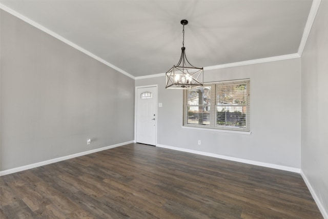 spare room featuring a chandelier, dark wood-type flooring, and ornamental molding