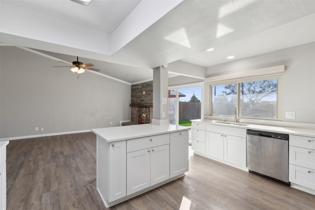 kitchen featuring vaulted ceiling, dishwasher, sink, and white cabinets