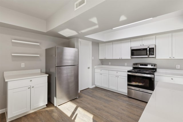 kitchen featuring appliances with stainless steel finishes, dark hardwood / wood-style floors, and white cabinets