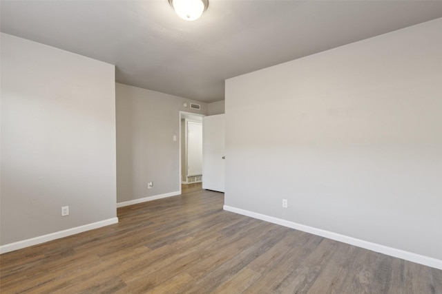 unfurnished room with dark hardwood / wood-style flooring