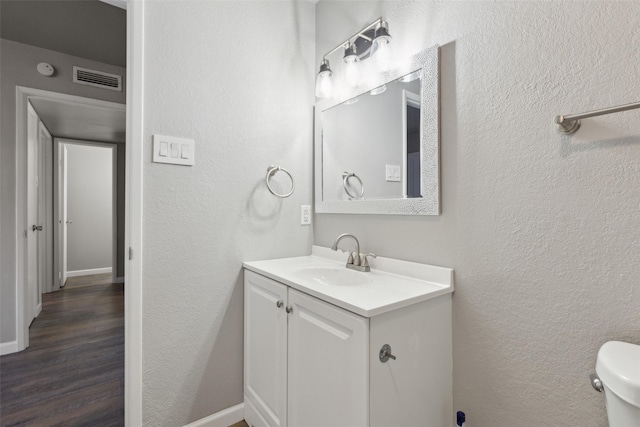 bathroom with hardwood / wood-style flooring, vanity, and toilet