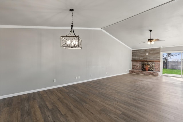 unfurnished living room featuring crown molding, a fireplace, dark hardwood / wood-style floors, and ceiling fan with notable chandelier