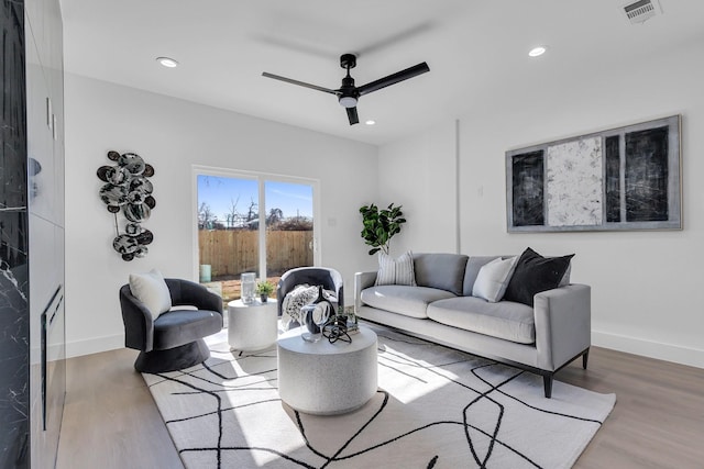 living area with recessed lighting, wood finished floors, visible vents, and baseboards