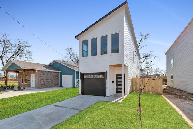 modern home featuring driveway, a front lawn, and fence