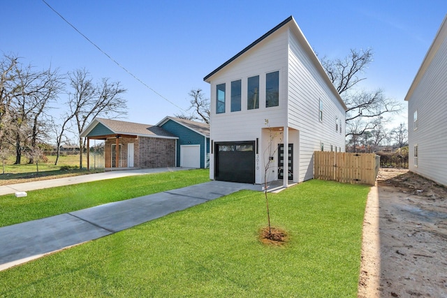 contemporary home with driveway, a front yard, and fence