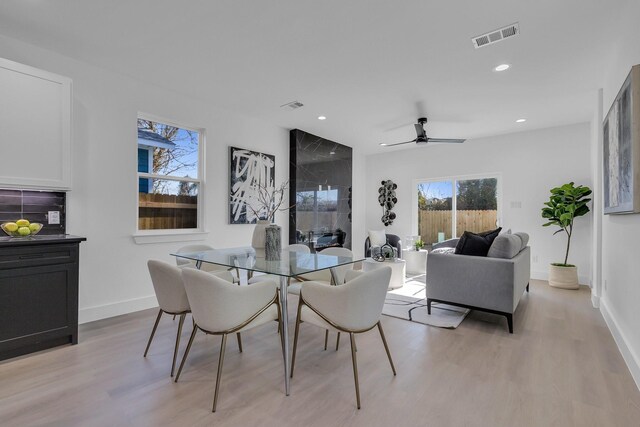 kitchen featuring sink, white cabinetry, stainless steel appliances, an island with sink, and decorative light fixtures