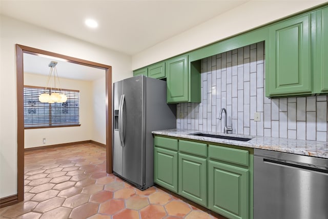 kitchen featuring sink, tasteful backsplash, green cabinets, decorative light fixtures, and appliances with stainless steel finishes