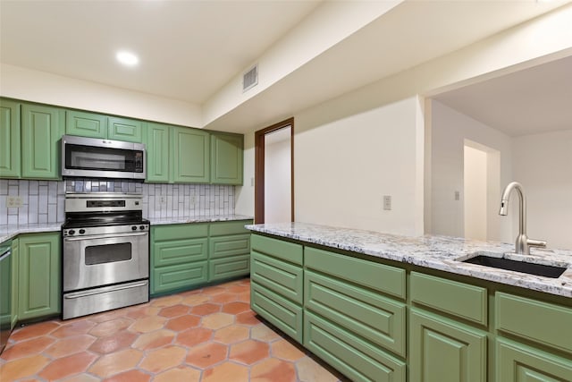 kitchen featuring backsplash, sink, stainless steel appliances, and green cabinetry