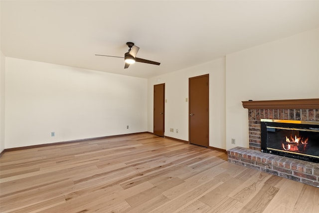 unfurnished living room featuring ceiling fan, light wood-type flooring, and a fireplace