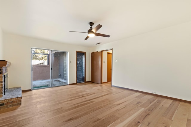 unfurnished living room with light hardwood / wood-style flooring, a brick fireplace, and ceiling fan