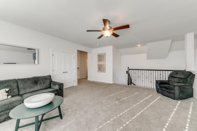 living area with ceiling fan and light carpet