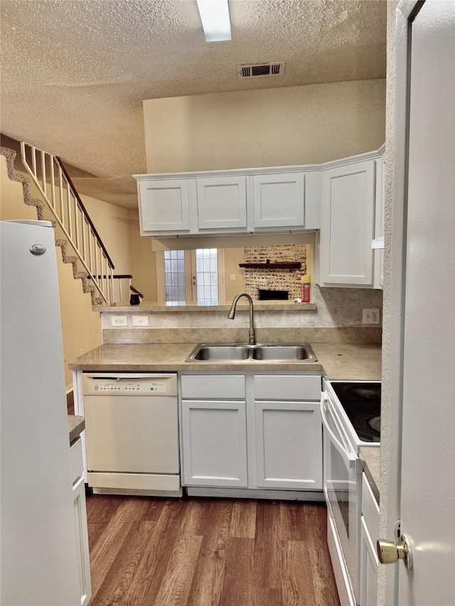 kitchen with dark hardwood / wood-style flooring, sink, white cabinets, and white appliances