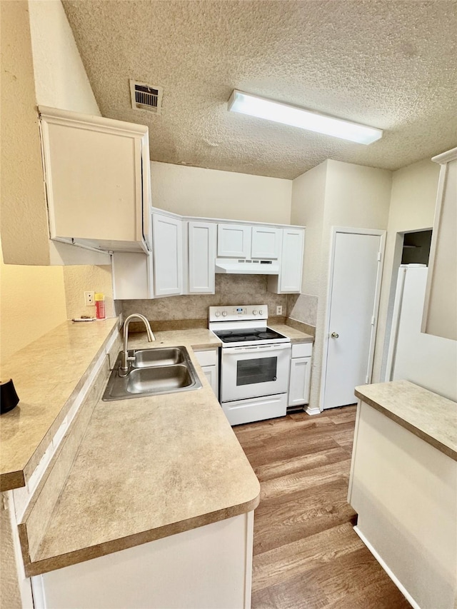 kitchen with sink, white appliances, light hardwood / wood-style flooring, a textured ceiling, and white cabinets