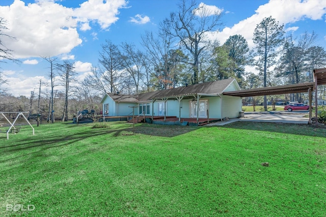 rear view of house featuring a carport and a lawn