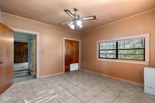 unfurnished bedroom with ornamental molding, light tile patterned flooring, and ceiling fan