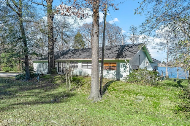 view of home's exterior featuring a water view and a lawn