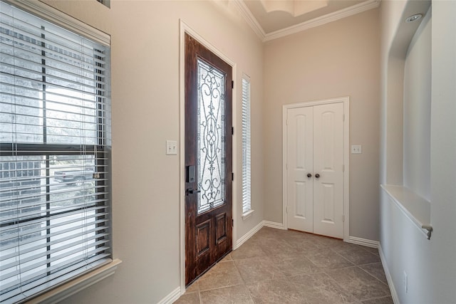 entrance foyer with light tile patterned floors, crown molding, and plenty of natural light