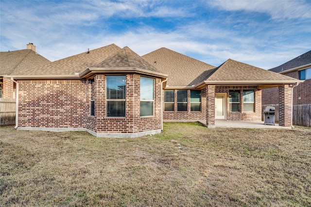 back of property with a lawn and a patio