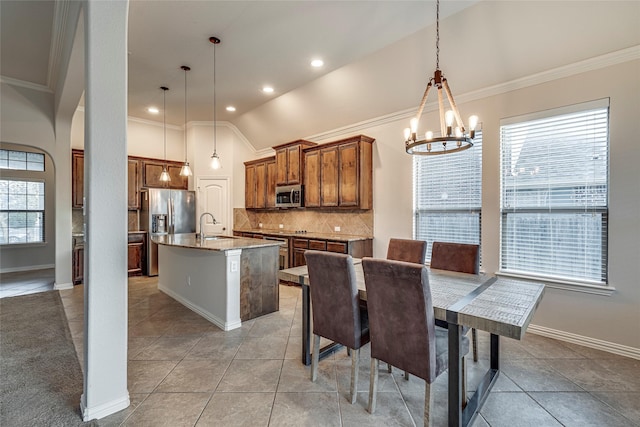 tiled dining room with crown molding, sink, a chandelier, and vaulted ceiling