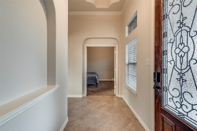 corridor featuring crown molding and light tile patterned floors