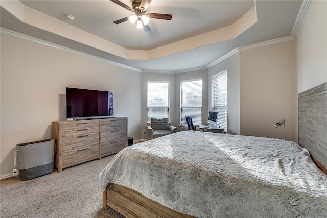 carpeted bedroom with crown molding, ceiling fan, and a tray ceiling