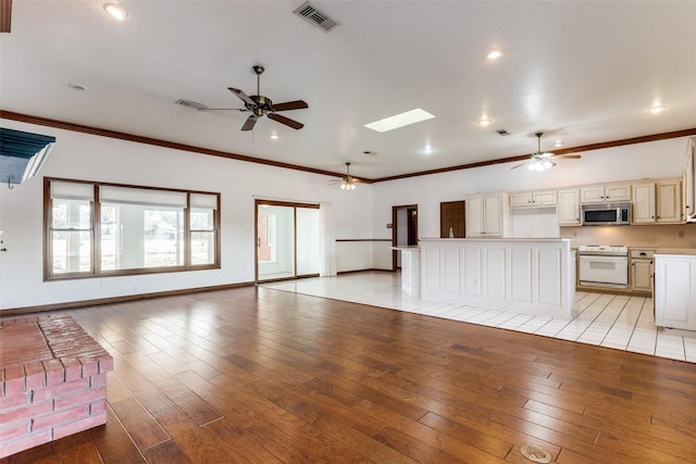 unfurnished living room with crown molding, a skylight, and light wood-type flooring