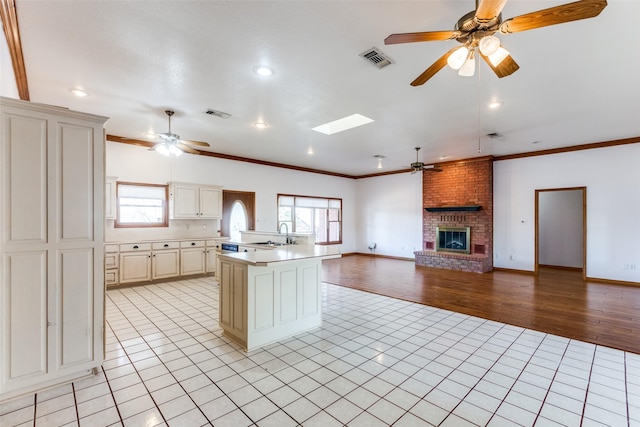 kitchen with light tile patterned floors, cream cabinets, and a healthy amount of sunlight