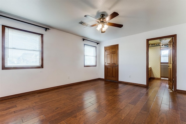 unfurnished bedroom with multiple windows, dark hardwood / wood-style floors, and ceiling fan