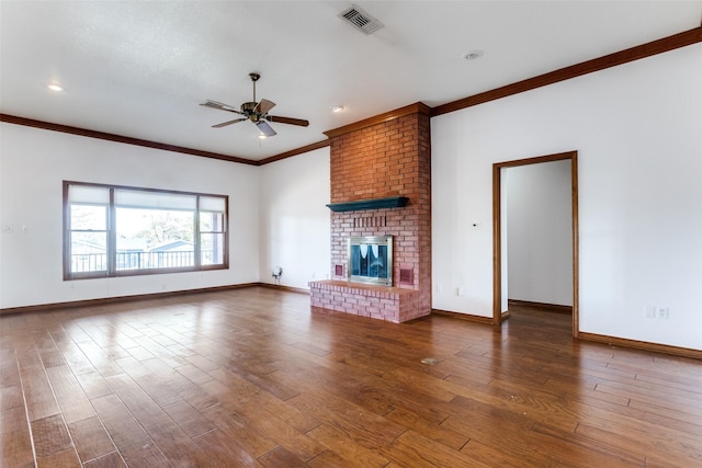 unfurnished living room featuring dark hardwood / wood-style flooring, a brick fireplace, crown molding, and ceiling fan