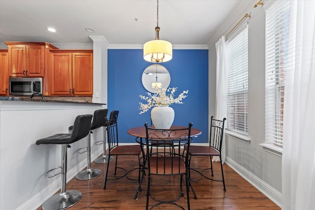 dining area featuring hardwood / wood-style flooring, sink, and ornamental molding