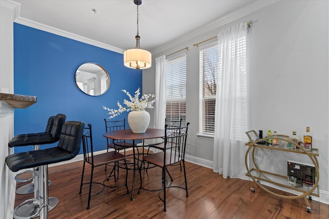 dining space with hardwood / wood-style flooring and crown molding