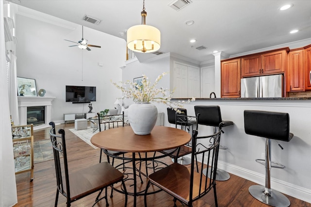 dining space with ceiling fan, ornamental molding, and hardwood / wood-style flooring