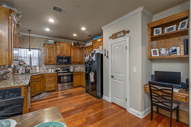 kitchen with pendant lighting, backsplash, black appliances, dark hardwood / wood-style floors, and light stone countertops