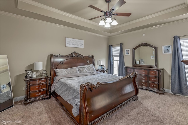 carpeted bedroom featuring a raised ceiling, ceiling fan, and crown molding