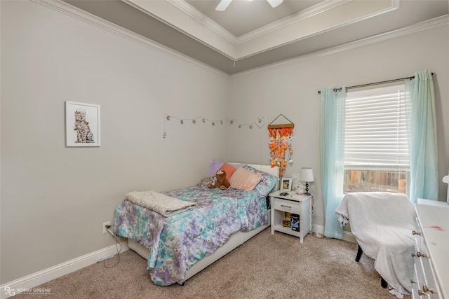 carpeted bedroom with a tray ceiling, ceiling fan, and ornamental molding