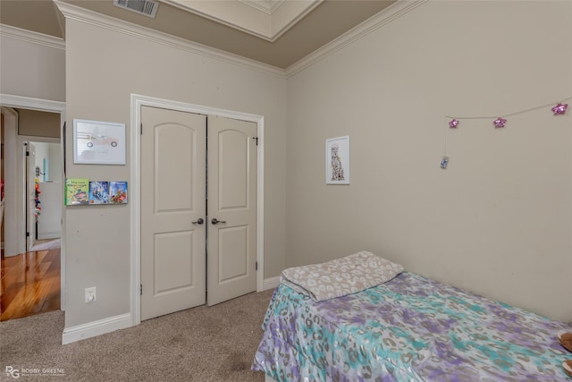 carpeted bedroom with a closet and ornamental molding