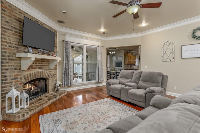 living room with a brick fireplace, ceiling fan, crown molding, and hardwood / wood-style flooring