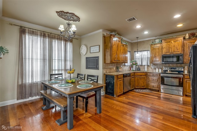 kitchen with sink, hanging light fixtures, dark hardwood / wood-style flooring, a chandelier, and black appliances