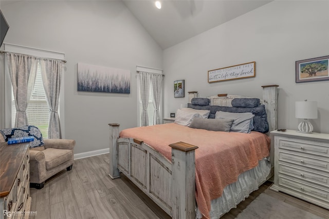 bedroom with light hardwood / wood-style floors, high vaulted ceiling, and multiple windows